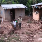 A mud-brick homestead with children nearby