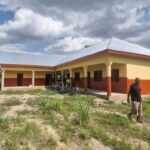 A finished school building with a person walking past it