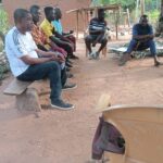 Men seated together on a bench outdoors