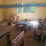 Empty classroom with small wooden chairs and tables