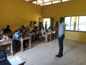 Teacher addressing seated parents and community members in a classroom
