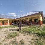 People gathered at the entrance of a newly finished school building